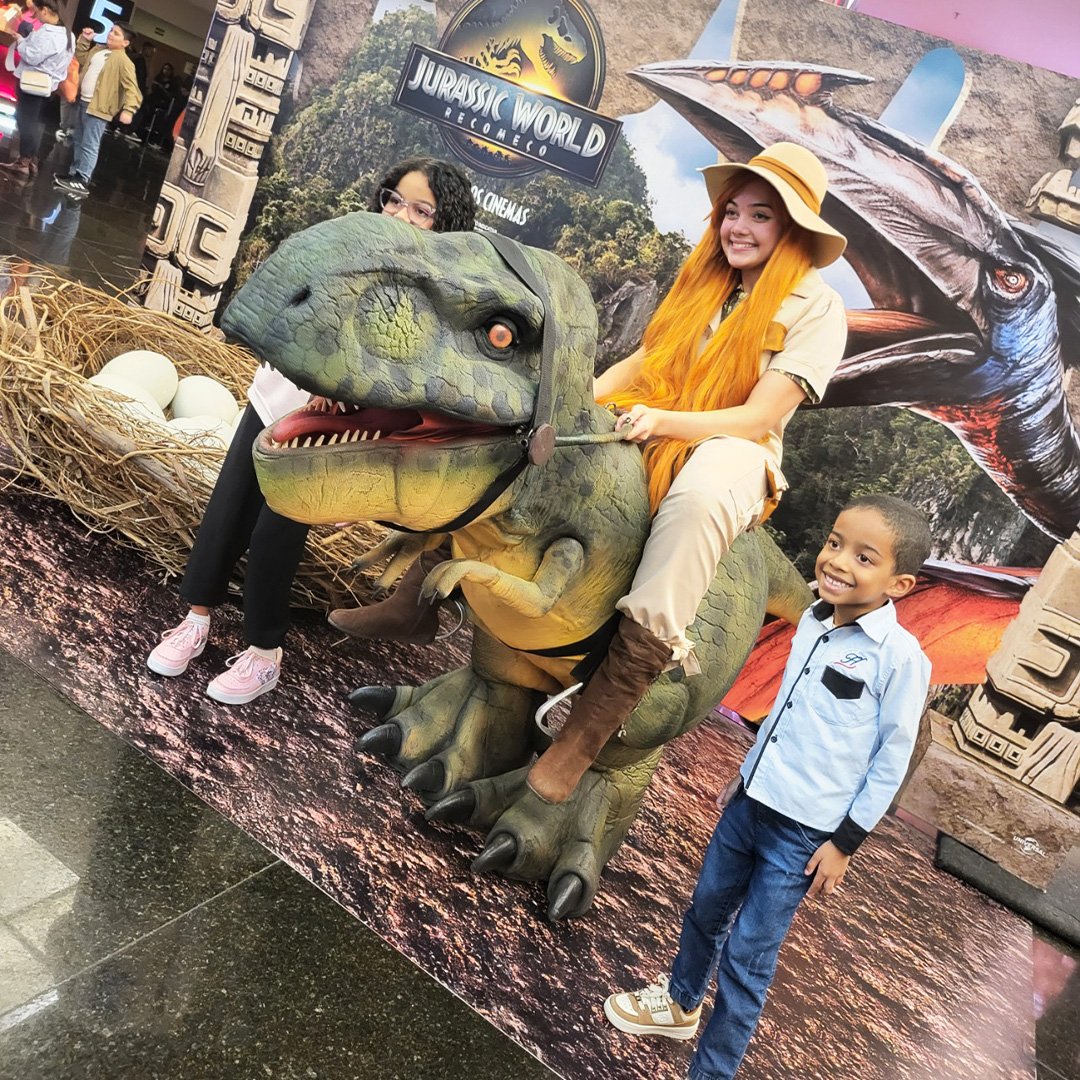 Crianças interagindo com dinossauro baby em aniversário no bairro Parateí em Santa Isabel