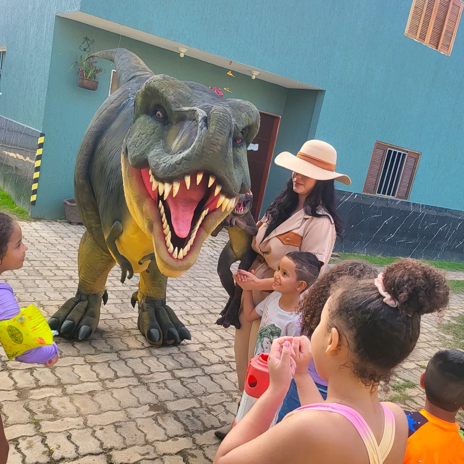 Atriz exploradora interagindo com dinossauro e crianças em evento em Barueri Atriz exploradora interagindo com dinossauro e crianças em evento em Barueri