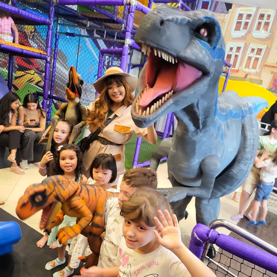 Atriz fantasiada de exploradora junto ao dinossauro Blue para contratar dinossauros personagens vivos em São José dos Campos