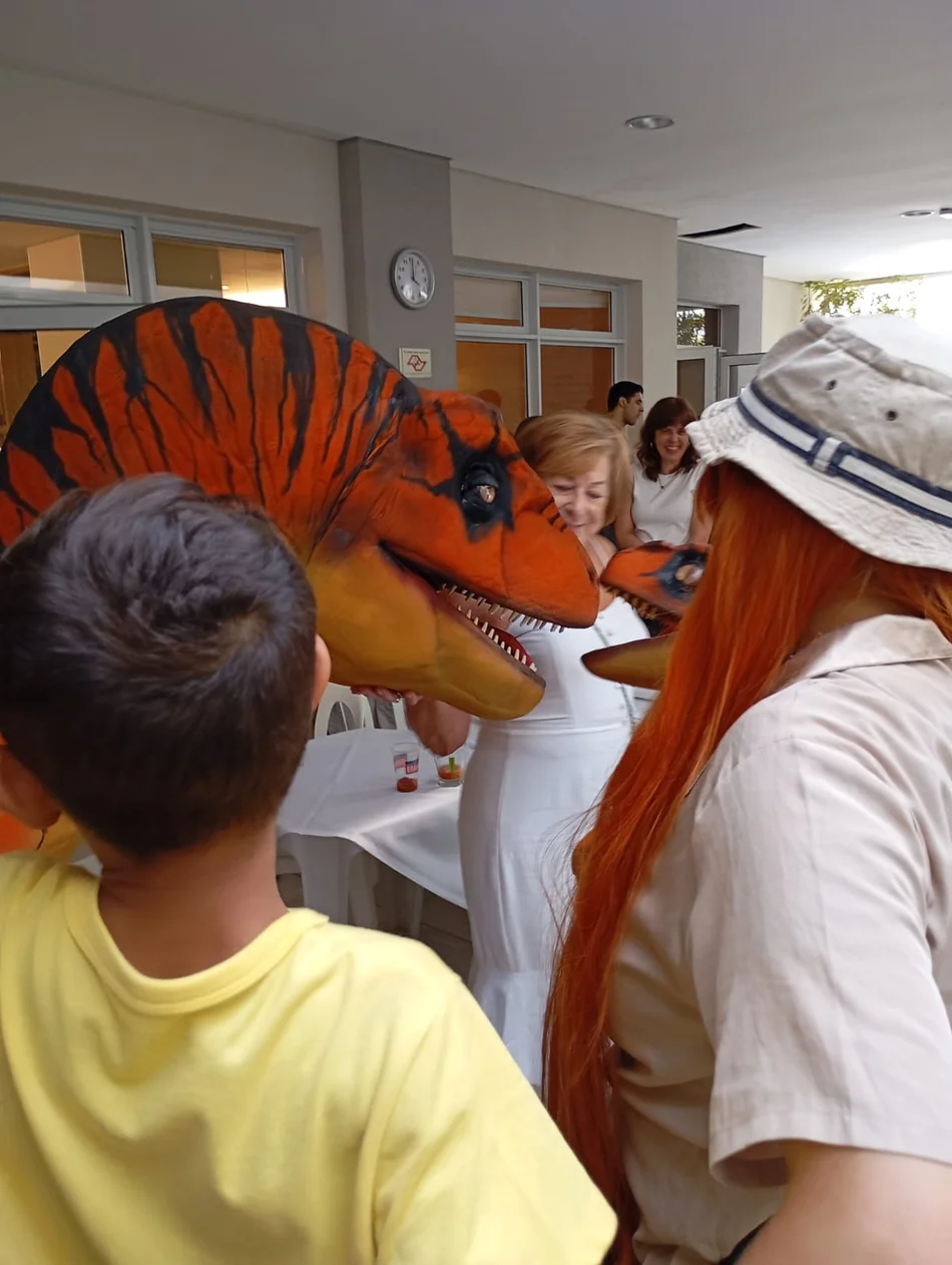 Crianças se alegrando com os Dinossauros personagens vivos Crianças se alegrando com os Dinossauros personagens vivos