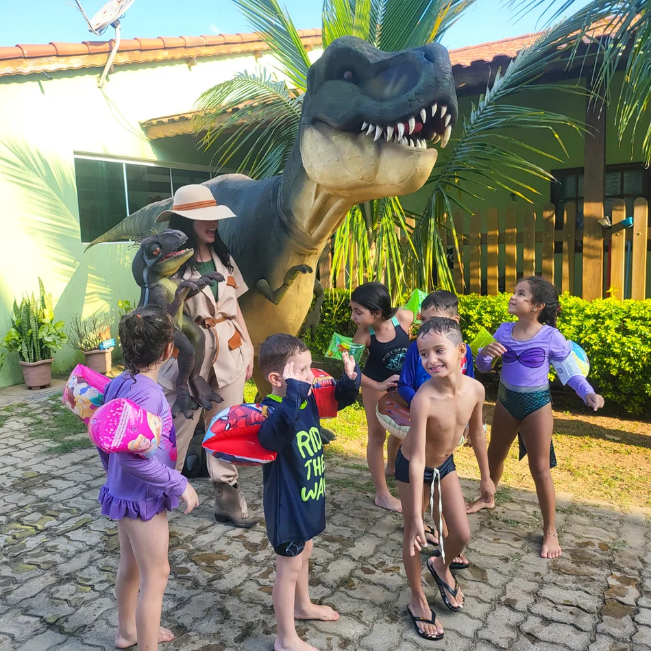 Crianças tirando fotos com dinossauro hiper realista em buffet infantil em Salto