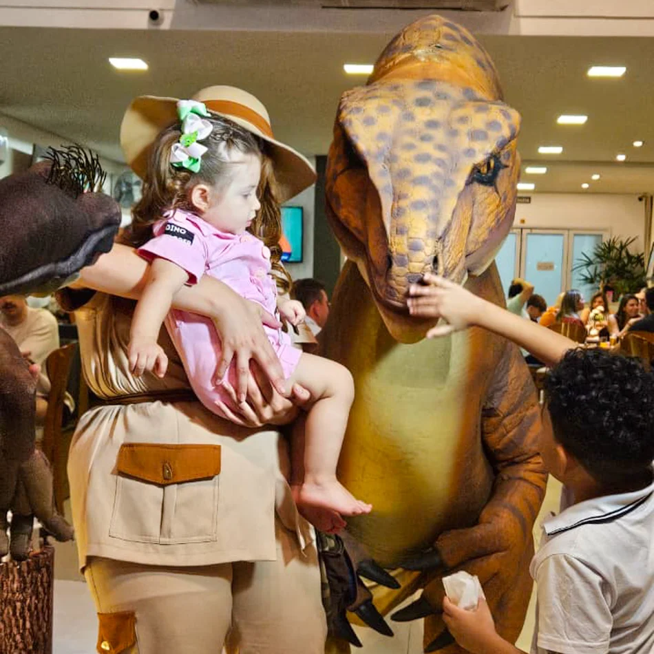 Personagem Vivo T-Rex Laranja posando em festa infantil no Buffet País das Maravilhas